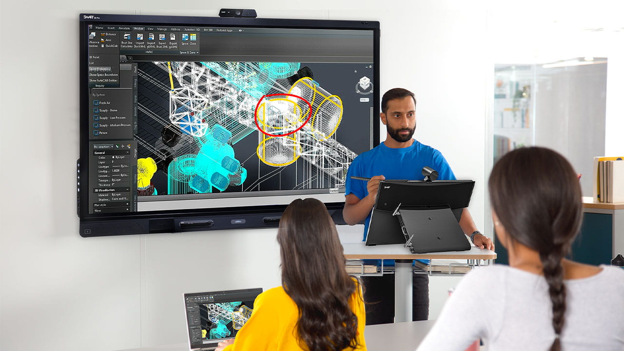 A professional presenting a 3D design on a SMART Board interactive display, using a SMART Board Mini Interactive Podium for seamless control.