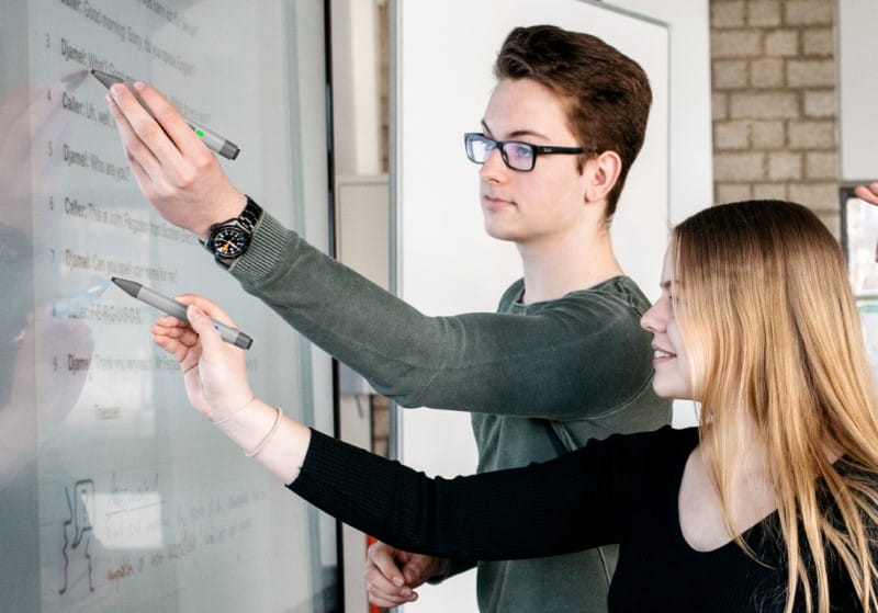 High school students using the RX series SMART Board for a literature lesson, underlining text and discussing analysis, fostering a collaborative learning environment.