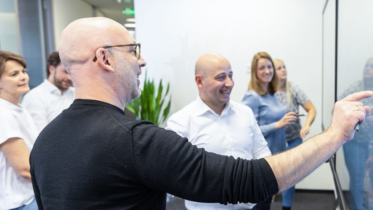 Business professionals interacting with a SMART board during a brainstorming session.