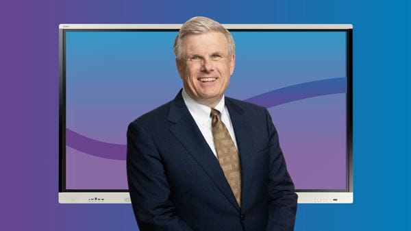 SMART’s CEO, Nicholas Svensson, standing in front of a SMART interactive display and a blue/purple background.