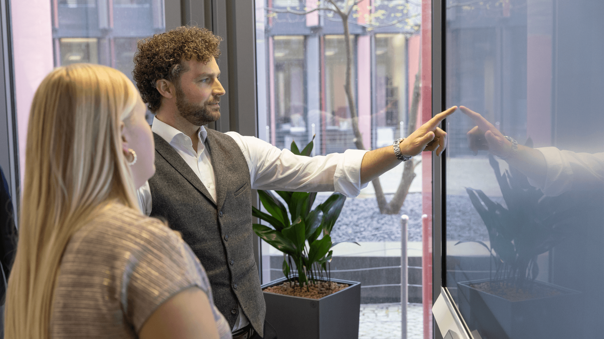 Two professionals interacting with a SMART Interactive Display for business.